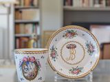 a cup and saucer sitting on a table in front of a bookshelf