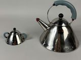 two tea kettles sitting next to each other on a table