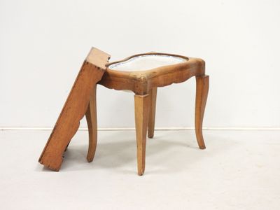 un petit tabouret en bois sur lequel est posé un miroir