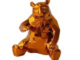 une statue d'ours en or brillant, assise sur ses pattes arrière