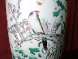 a white vase with a bird on it on a table