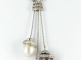 un gros plan sur un collier orné de trois perles