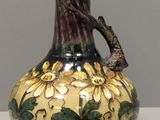 un vase avec un oiseau posé sur une table