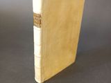 an old book sitting on top of a table on a black surface