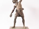 bronze statue of a man holding a tennis racquet on a marble base