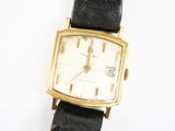 une montre posée sur un bracelet en cuir noir