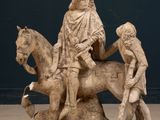 a statue of a man riding a horse with two children on it