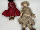 two dolls are sitting next to each other on a white surface
