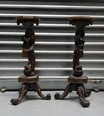 pair of antique carved wood candlesticks with lion heads on them
