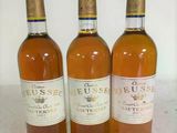 three bottles of wine sitting on a table next to each other