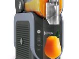 an orange drink being poured into a juicer
