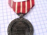 une médaille entourée d'un ruban, posée sur une feuille de papier