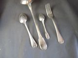 five silver spoons and two silver spoons on a table