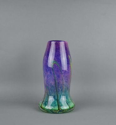 a purple and green vase sitting on top of a table