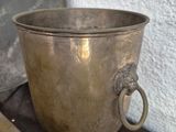 a silver cup sitting on a table next to a book