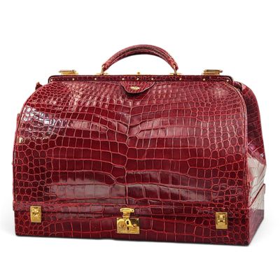 une image représentant une valise rouge posée sur une surface blanche