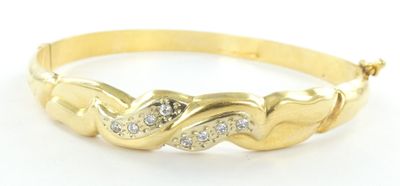 gros plan d'un bracelet en or avec des diamants sur fond blanc
