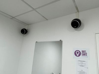 un miroir dans un coin d'une pièce, avec une affiche accrochée au mur