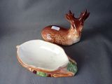two ceramic deer figurines sitting next to each other on a table