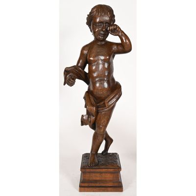 une statue en bronze représentant un garçon tenant un téléphone à la main