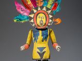 une statue en bois représentant un homme avec des plumes sur la tête