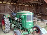 un tracteur vert garé à l'intérieur d'une grange