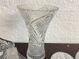 several pieces of glass on a table with a vase and bowls