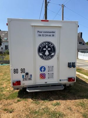 un camion blanc garé sur le bord de la route