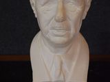 a bust of a man in a suit and tie on a table