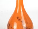 an orange vase sitting on a table with a white background