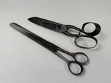 two pairs of scissors sitting on a white surface