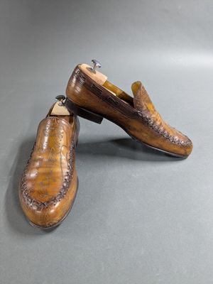 two pairs of shoes are sitting on top of a gray surface