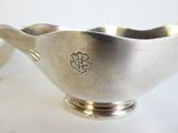 un bol en argent avec une cuillère sur une table