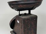 an old scale with a bowl on top of it
