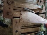 un homme debout à côté d'une machine qui découpe un morceau de bois