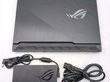 the asus laptop is sitting on a white surface next to a charger