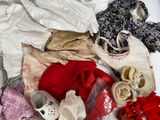 a pile of clothes and shoes sitting on a bed