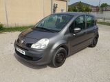 La petite voiture est garée sur le parking à côté de l'immeuble.