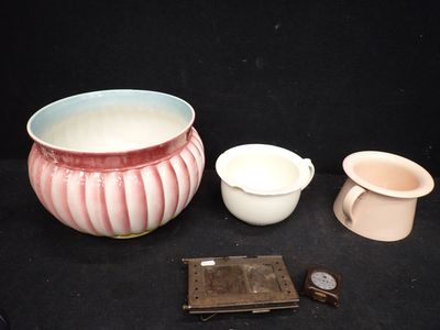 un vase rose et blanc, un bol et d'autres objets sur fond noir