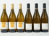 six bouteilles de vin sont alignées sur une table