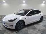 the white tesla model 3 is parked in a clean room