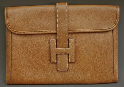 un porte-monnaie en cuir marron orné d'une croix sur le devant