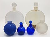 quatre bouteilles en verre de couleurs différentes posées les unes à côté des autres