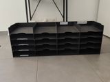 a black shelf with several bins on it in a room