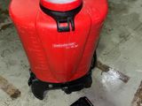 a red container sitting on the ground next to a black object