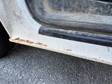 a close up of a dirty car door with rust on it