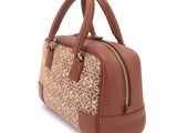 the brown handbag is sitting on a white surface