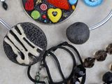 many different necklaces and bracelets that are on a table