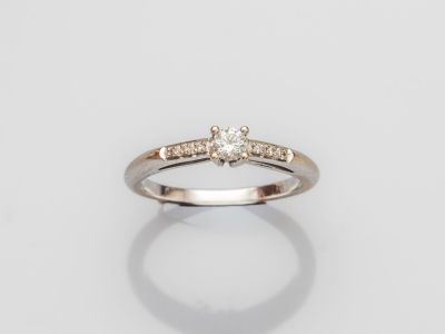une bague en or blanc avec un diamant serti au centre