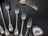 a lot of silver spoons and forks on the table